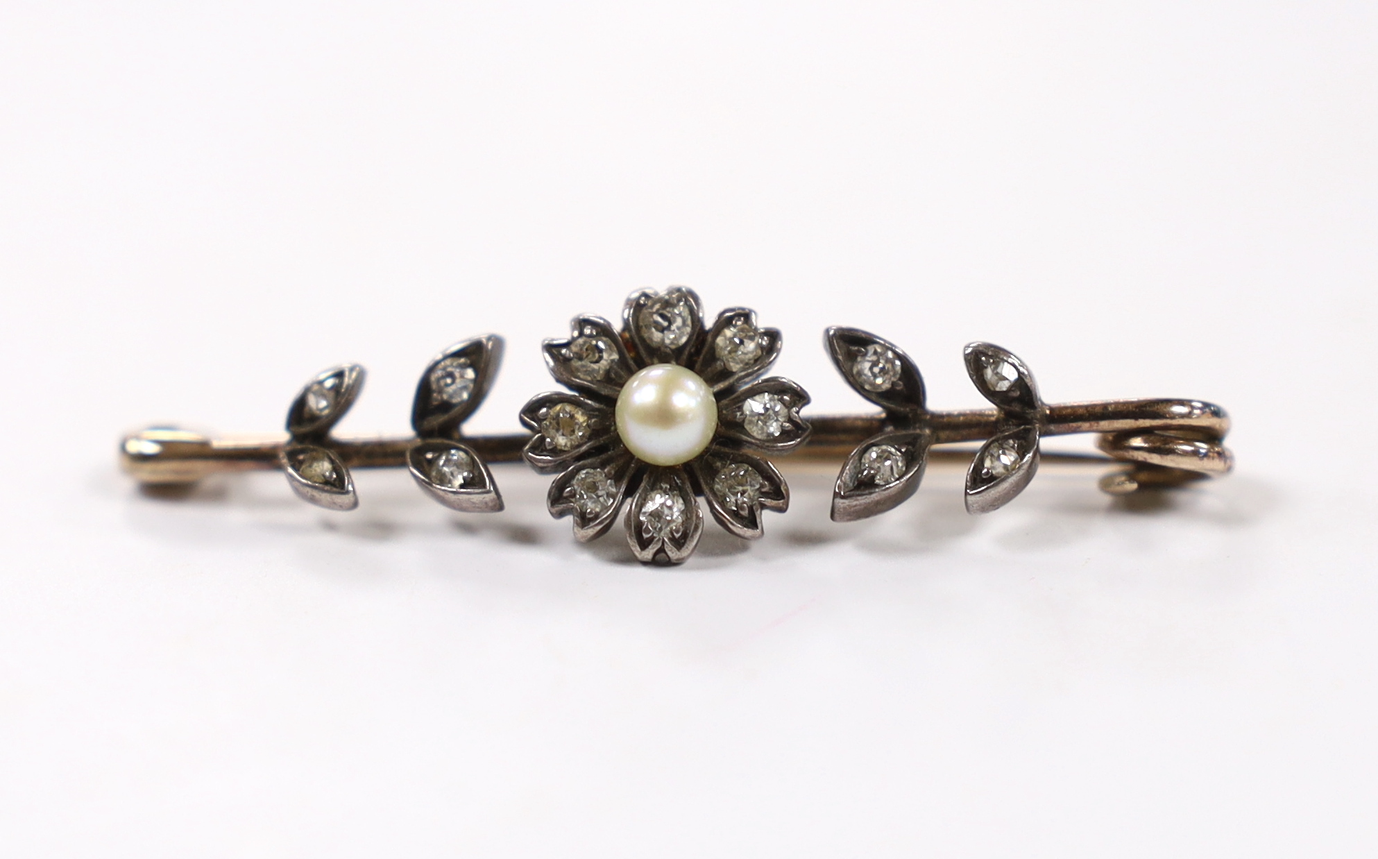 A late Victorian yellow and white metal, seed pearl and diamond cluster set flower head bar brooch, 44mm, gross weight 3.5 grams.